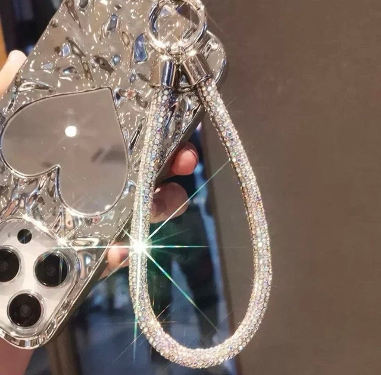 Shiny rhinestone phone strap attached to phone case showing sparkling detail