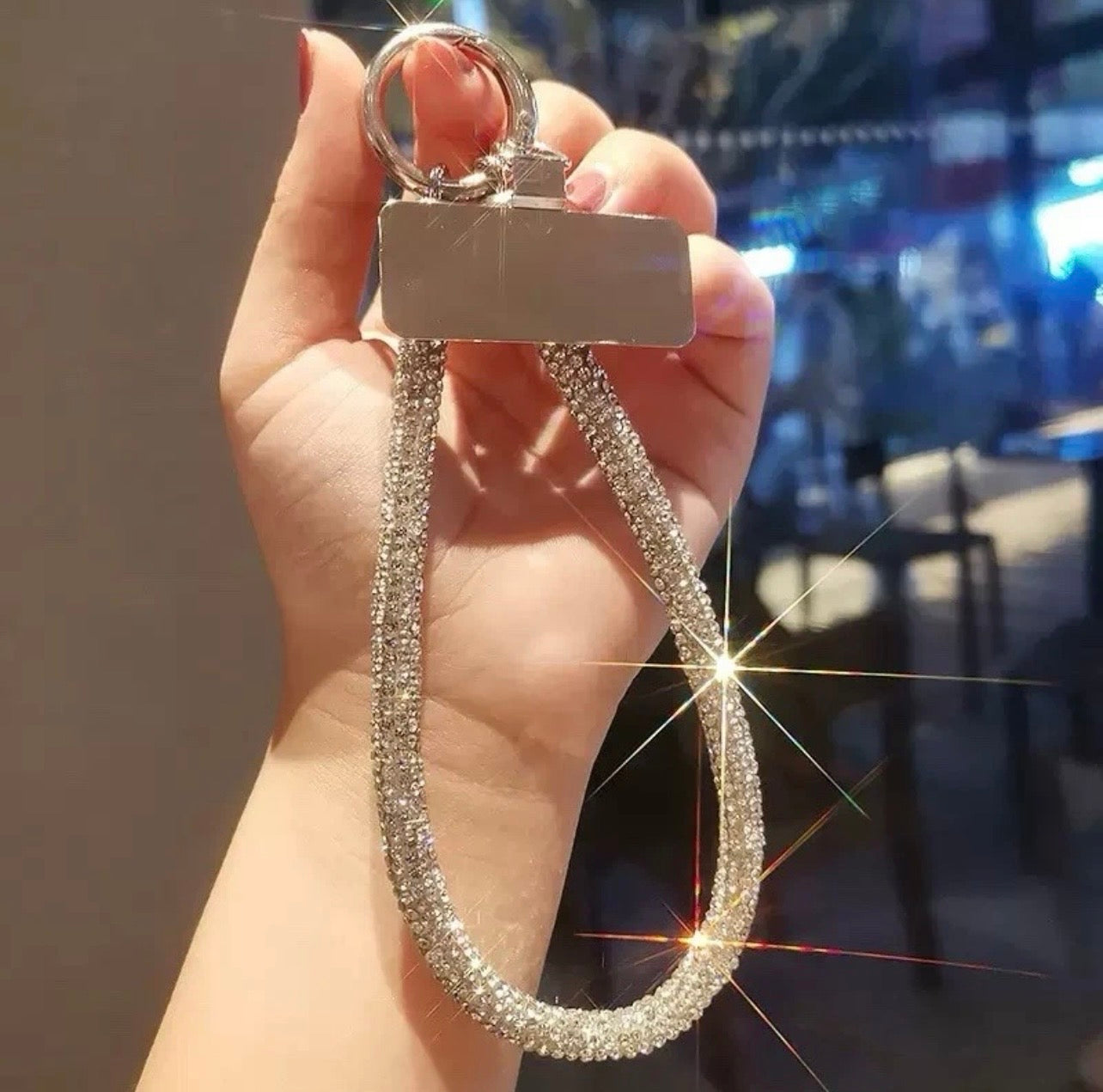 Close-up of metal anti-drop clasp on silver rhinestone phone strap